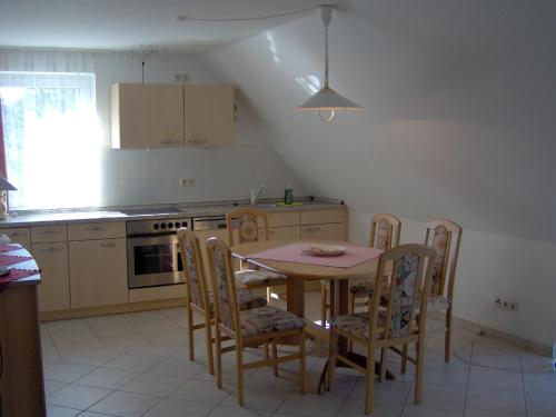 a kitchen with a table and chairs and a table and a kitchen at Haus Galerie 1. OG in Karlshagen