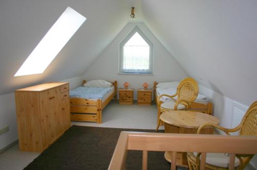 a attic room with a bed and a table and chairs at Haus Galerie 1. OG in Ostseebad Karlshagen