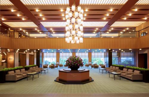 un gran vestíbulo con sillas y una lámpara de araña en Hotel Okura Kobe en Kobe