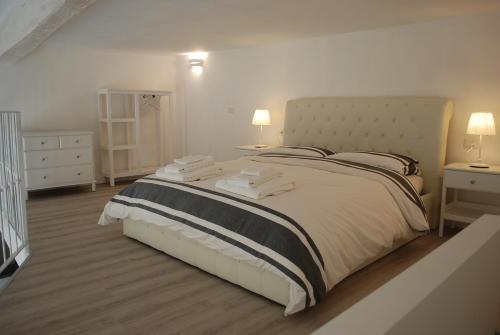 a white bedroom with a large bed with two lamps at Berardi Palace - Vigna Nuova Loft in Florence