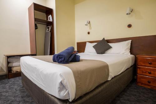 a bedroom with a bed with a stuffed animal on it at Pioneer Station Motor Inn in Swan Hill