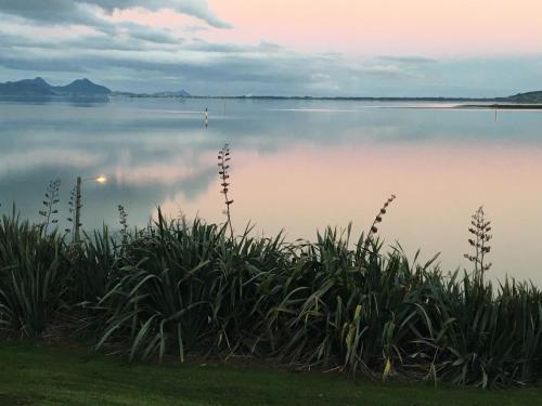 a view of a large lake with clouds in the sky at Beach Lane Apartment in Whangarei