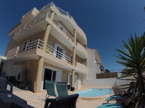 a large house with a swimming pool in front of it at My Guest House in Portimão
