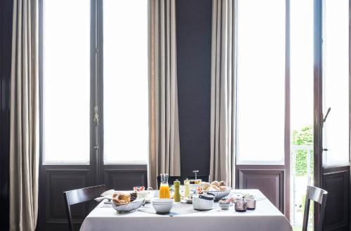 a table with a white table cloth and food on it at B&B Dusk till dawn in Mechelen