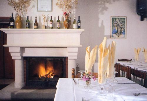 a dining room with a fireplace and a table with a table cloth at Genziana B&B by VM in Opi