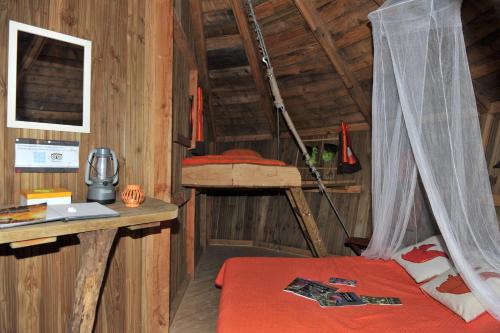 a room with a bunk bed and a desk and a ladder at Les cabanes du lac du Der in Giffaumont