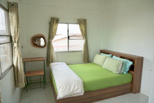 a small bedroom with a bed with a window at Tourist Inn in Chiang Rai