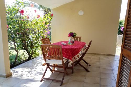 una mesa de comedor con un mantel rojo. en Trilocale Turagri 45 en Costa Rei