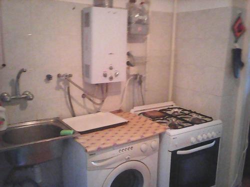 a small kitchen with a stove and a sink at Бабушкин уют в РУСТАВИ in Rustavi