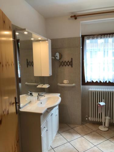 y baño con lavabo y espejo. en Residence Dromaè cipat 68018, en Ledro