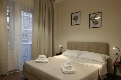a bedroom with a bed with two towels on it at Khome Rooms & Apartment in Catania