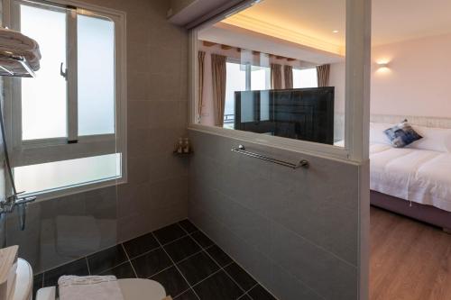 a bathroom with a shower with a tv and a tub at Sea Dragonfly in Yanliau