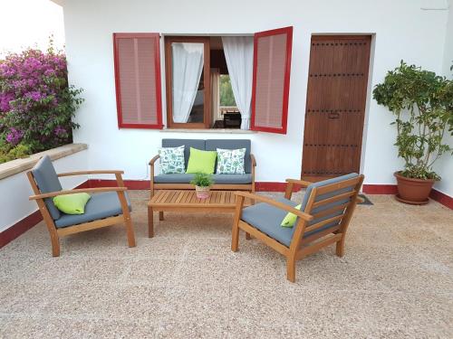 un patio con 2 sillas, una mesa y un sofá en Finca Sa Cova de Mallorca, en Sencelles