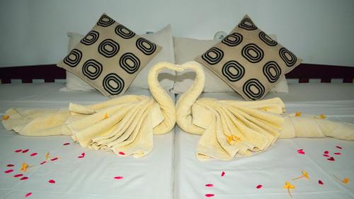 two swans made out of towels on a bed at Palitha Homestay in Sigiriya
