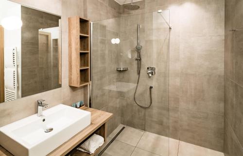 La salle de bains est pourvue d'un lavabo et d'une douche. dans l'établissement Hotel Plattenhof, à Termeno