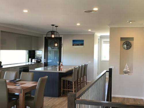 a kitchen and dining room with a table and chairs at Bunya By The Sea in Cape Woolamai