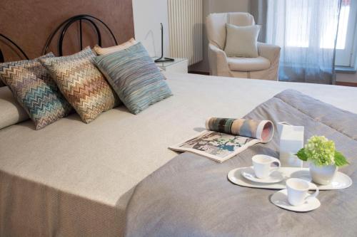 uma cama com duas chávenas e uma revista em La Finestra sul Borgo em Alba