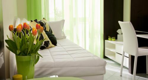 a white bed with orange tulips in a green vase at Sorrento Flats in Sorrento