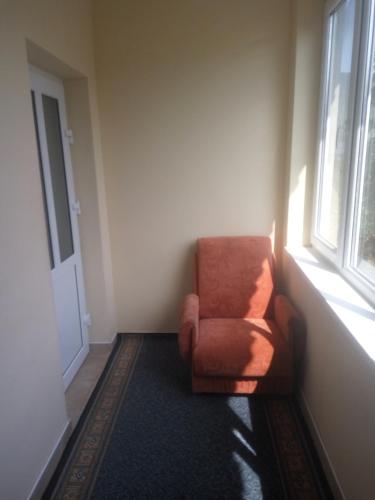 an orange chair in a room with a window at Room on Galic'ka in Yaremche