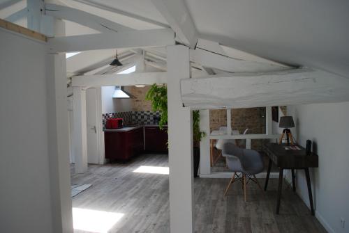 a living room with a table and a desk at Ecurie de la Grange l'Abbé in Le Langon