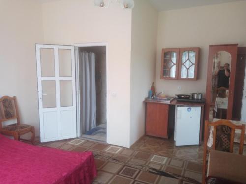 ヤレムチャにあるRoom on Galic'kaのベッド付きの部屋、ドア付きのキッチンが備わる客室です。