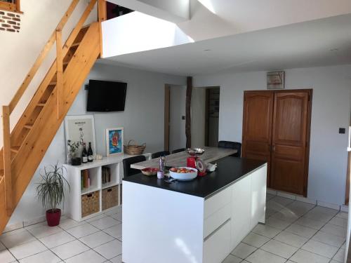 a kitchen with white cabinets and a black counter top at 2 chambres dans maison calme proches des châteaux de la Loire in Veigné