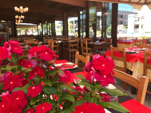 une table avec des fleurs rouges devant un restaurant dans l'établissement Il Casale, à Martinsicuro