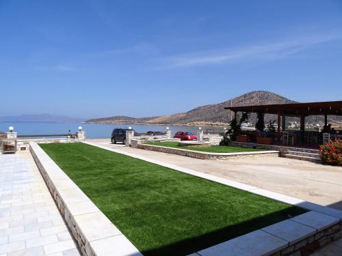 a pavilion with green grass next to the water at Avgerinos Village in Agiassos