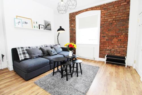 a living room with a couch and a brick wall at Stylish Flat in 1860's Listed Building in Edinburgh