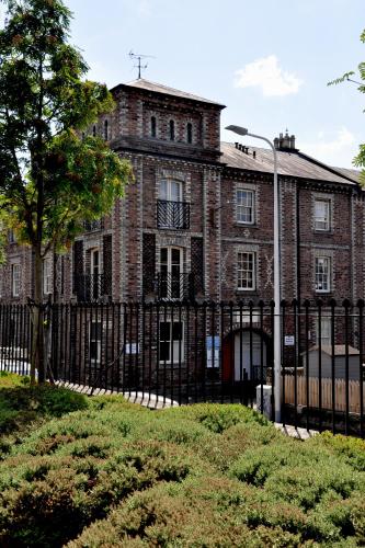 an old brick building with a black fence at Stylish Flat in 1860's Listed Building in Edinburgh