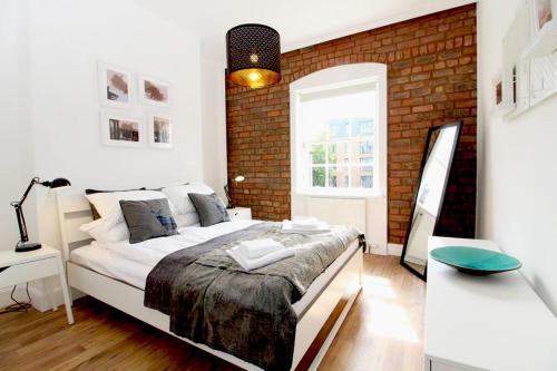 um quarto com uma cama e uma parede de tijolos em Stylish Flat in 1860's Listed Building em Edimburgo