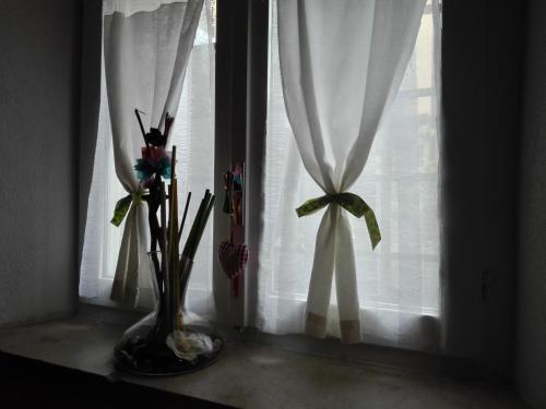 a vase with flowers in it next to a window at YHouse 33 in Trento