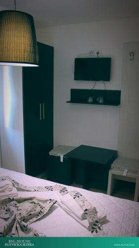 a bedroom with a bed and a desk and a chair at House Korina B&B in Ličko Petrovo Selo