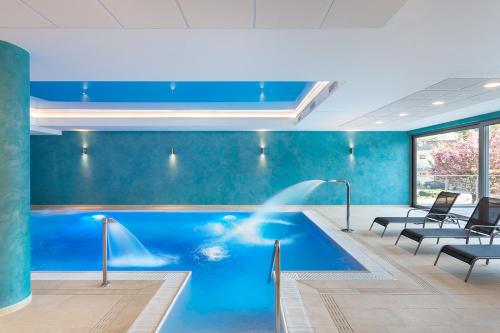 a swimming pool with a fountain in a office building at Hotel Panorama in Trenčianske Teplice