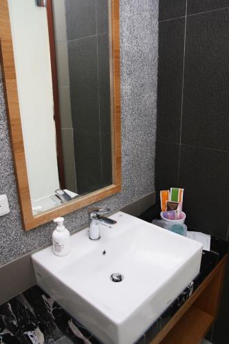 a bathroom with a white sink and a mirror at 野居海景渡假民宿Simple Life Home Stay in Magong