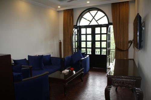 a living room with a blue couch and a window at Shangrila Hotels and Resort in Murree