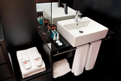 a bathroom with a sink, mirror, and towel rack at Axel Hotel Berlin-Adults Only in Berlin