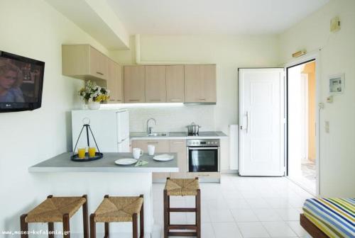 a kitchen with a counter and two stools in it at Muses Studios Sami in Sami