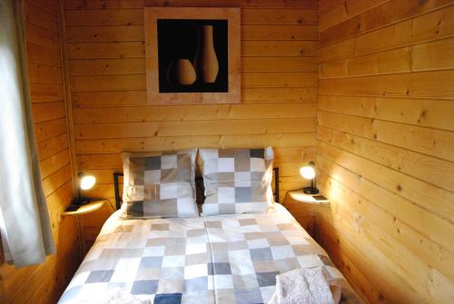 una camera da letto con letto in una camera in legno di The Cabin with heated outdoor pool a Chalandrey