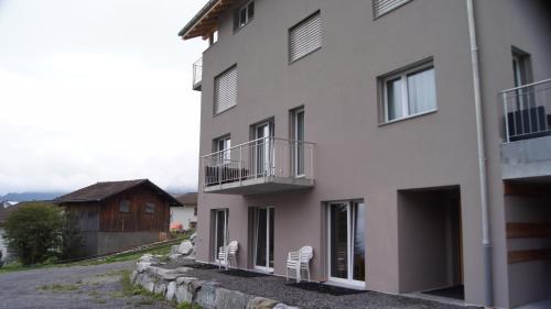 VellaにあるHaus Baraccaの白い椅子2脚が隣接する白い建物