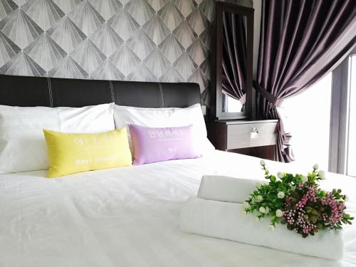 um quarto com uma cama branca e 2 almofadas coloridas em Country Garden Danga Bay , Royal Strand em Johor Bahru