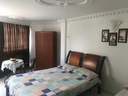 1 dormitorio con 1 cama, 1 mesa y 1 silla en Santa Marta Apartamentos Salazar - Velero, en Santa Marta