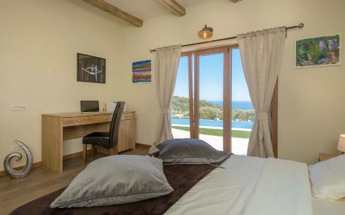 sypialnia z łóżkiem i biurkiem z oknem w obiekcie Luxury Villa Galapagos Hvar Town w Hvarze