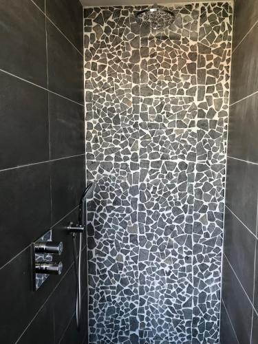 a bathroom with a shower with a patterned wall at cafe 't Vonderke in Eindhoven