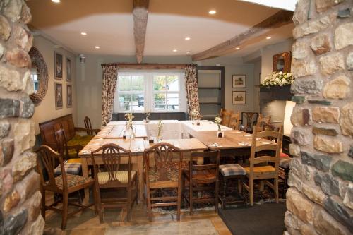 una sala da pranzo con un grande tavolo in legno e sedie di The Marton Arms a Ingleton