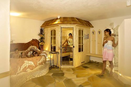 a woman standing in front of a room with a bedroom at Cesa Sara in Ortisei