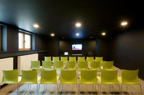 a conference room with yellow chairs and a flat screen tv at Axel Hotel Berlin - Adults Only in Berlin