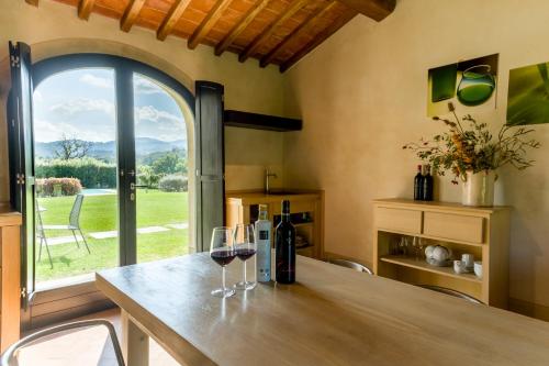 a kitchen with a table with two glasses of wine at Tenuta San Jacopo - Agriturismo in Cavriglia