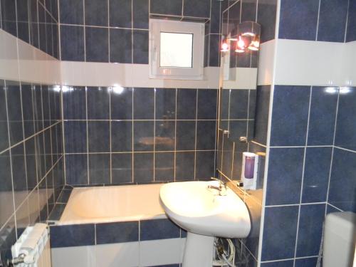 a bathroom with a sink and a bath tub at Apartament Silva Busteni in Buşteni