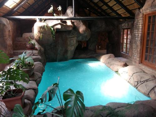 a swimming pool in a house with a stone wall at Pride Rock Accommodation in Middelburg